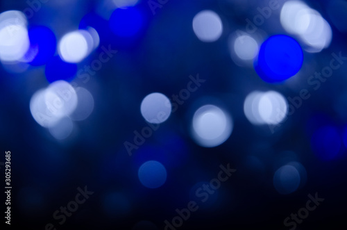 Abstract bokeh of blue and white lights on a dark background