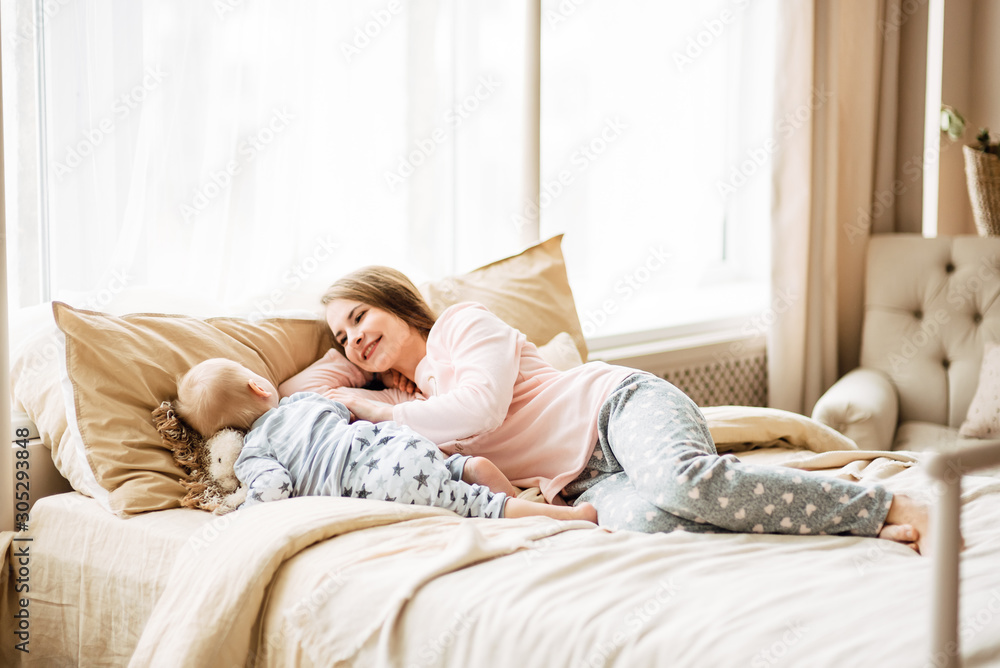 Young mother and son are playing in the bright room of his house. Cute baby boy with his mom. Happy and cute family chatting with baby Young mother and son are playing in the bright room of his house. Cute baby boy with his mom. Happy and cute family chatting with baby