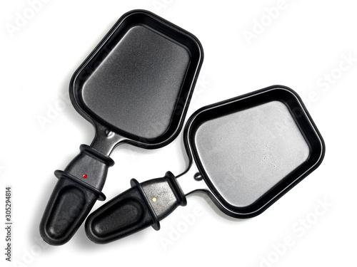 Fotografía Two empty raclette pans for melted cheese , close up
