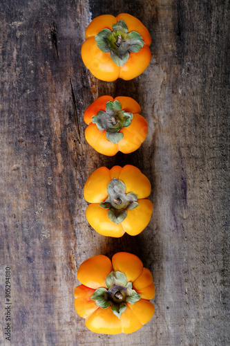 A new harvest. Juicy ripe persimmon on a wooden table.