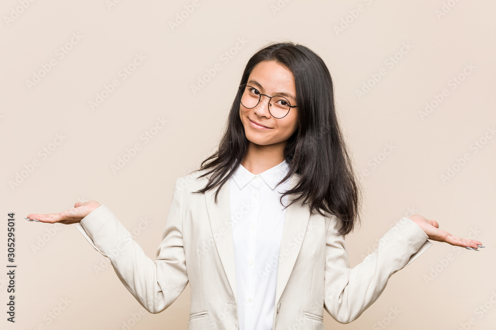 Young business chinese woman doubting and shrugging shoulders in questioning gesture. Young business chinese woman doubting and shrugging shoulders in questioning gesture.