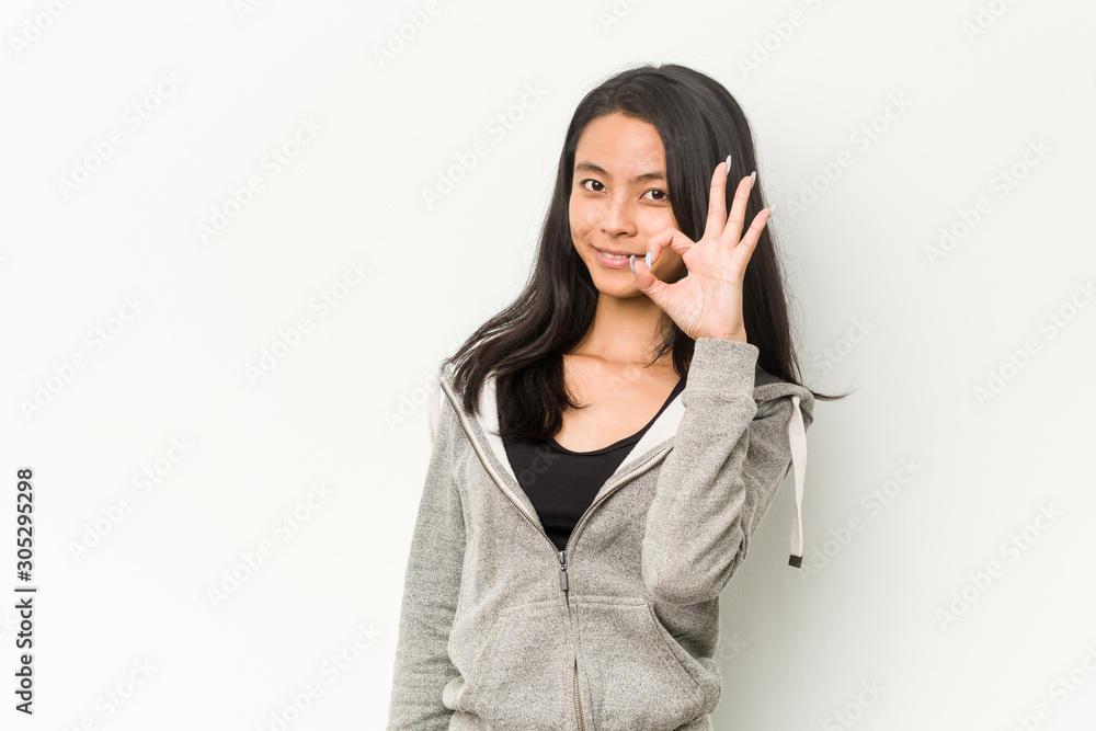 Young fitness chinese woman cheerful and confident showing ok gesture. Young fitness chinese woman cheerful and confident showing ok gesture.