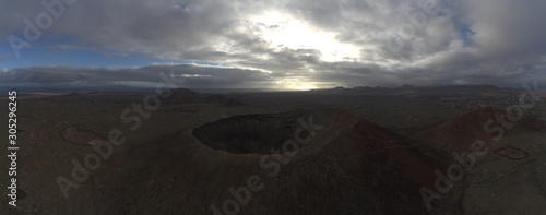 Volcano aerial panoramic view with desert and cloudy sky
