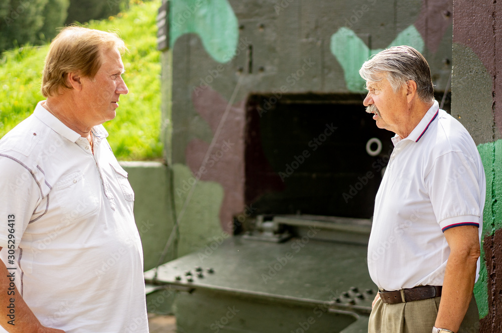 Mature men, tourists, on a tour of the military history Museum on a Sunny day. Mature men, tourists, on a tour of the military history Museum on a Sunny day.