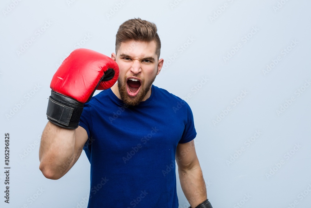 Young caucasian man wearing a boxing gloves Young caucasian man wearing a boxing gloves
