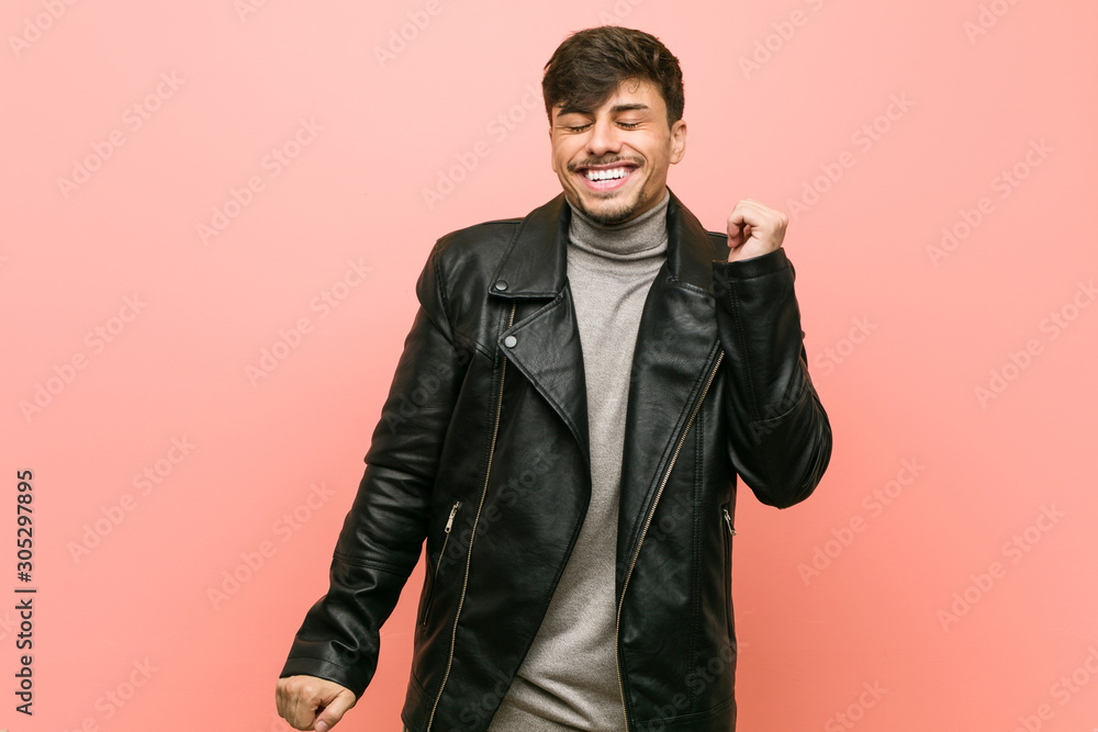 Young hispanic man wearing a leather jacket dancing and having fun. Young hispanic man wearing a leather jacket dancing and having fun.