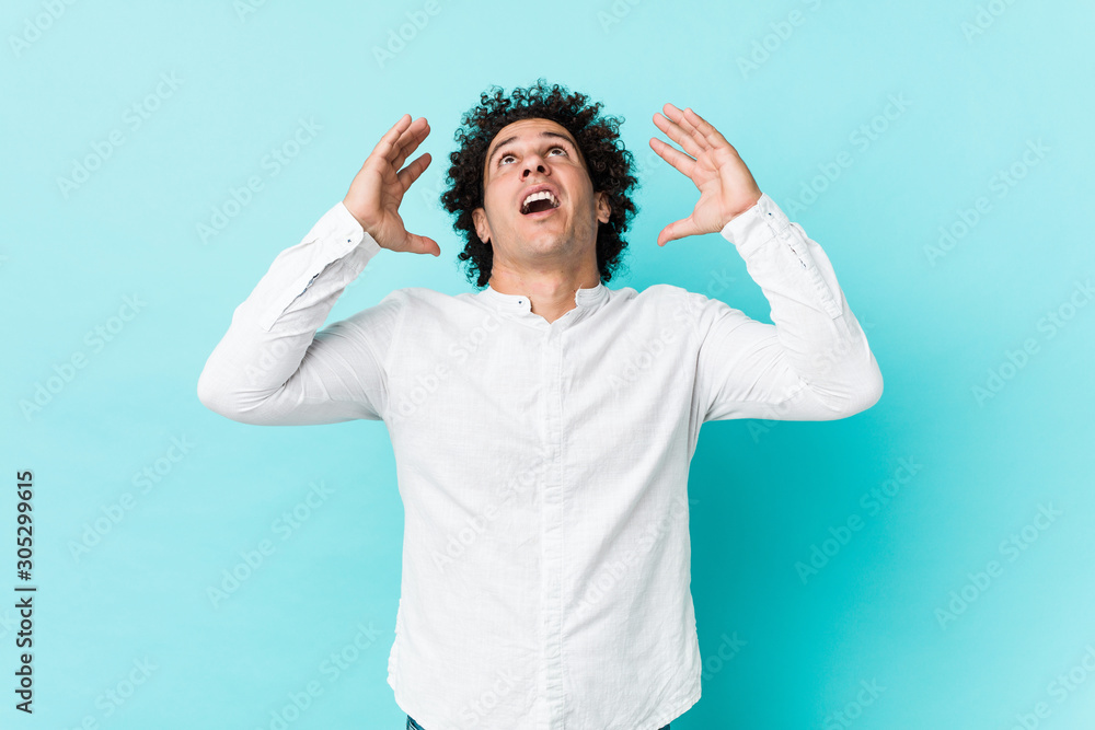 Young curly mature man wearing an elegant shirt screaming to the sky, looking up, frustrated. Young curly mature man wearing an elegant shirt screaming to the sky, looking up, frustrated.