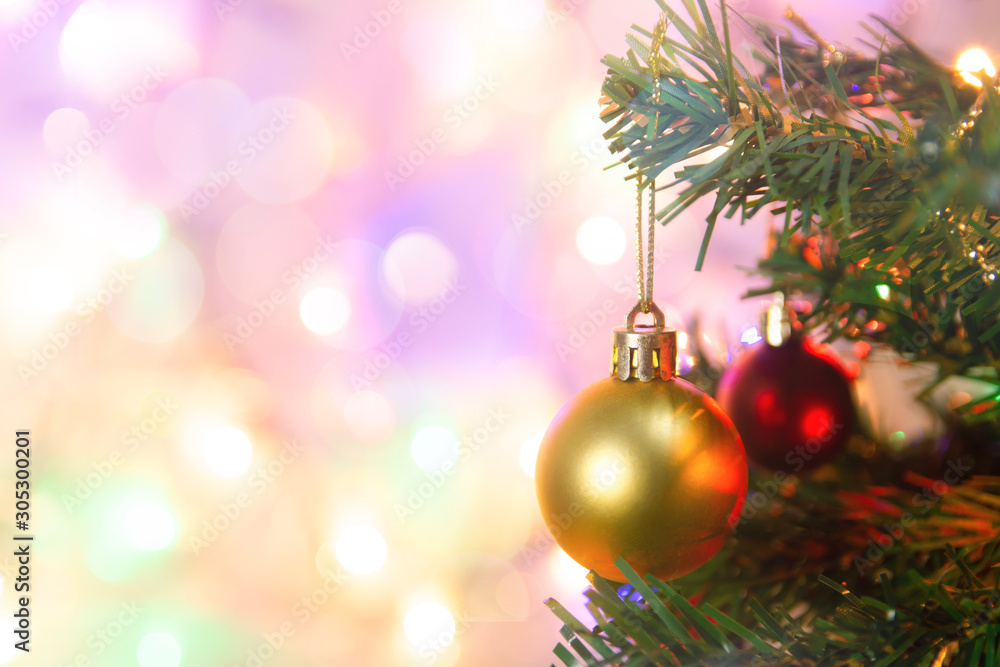 Fototapeta premium Christmas decoration. Hanging gold balls on pine branches Christmas tree garland and ornaments over abstract bokeh background with copy space.