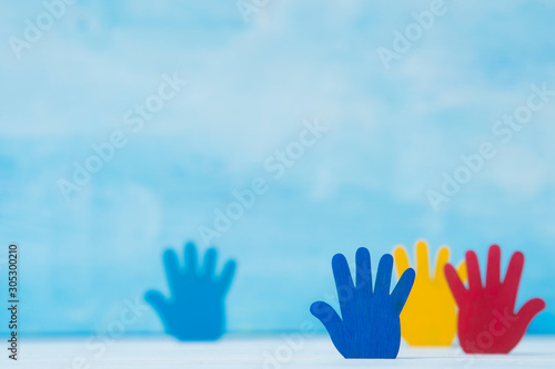 Colorfull puzzles hands on blue background. World Autism Awareness Day Concept photo
