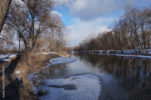 landscape of a winter river with open water and snowy shores