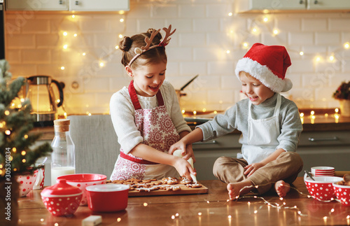 happy children boy and girl bake christmas cookies.