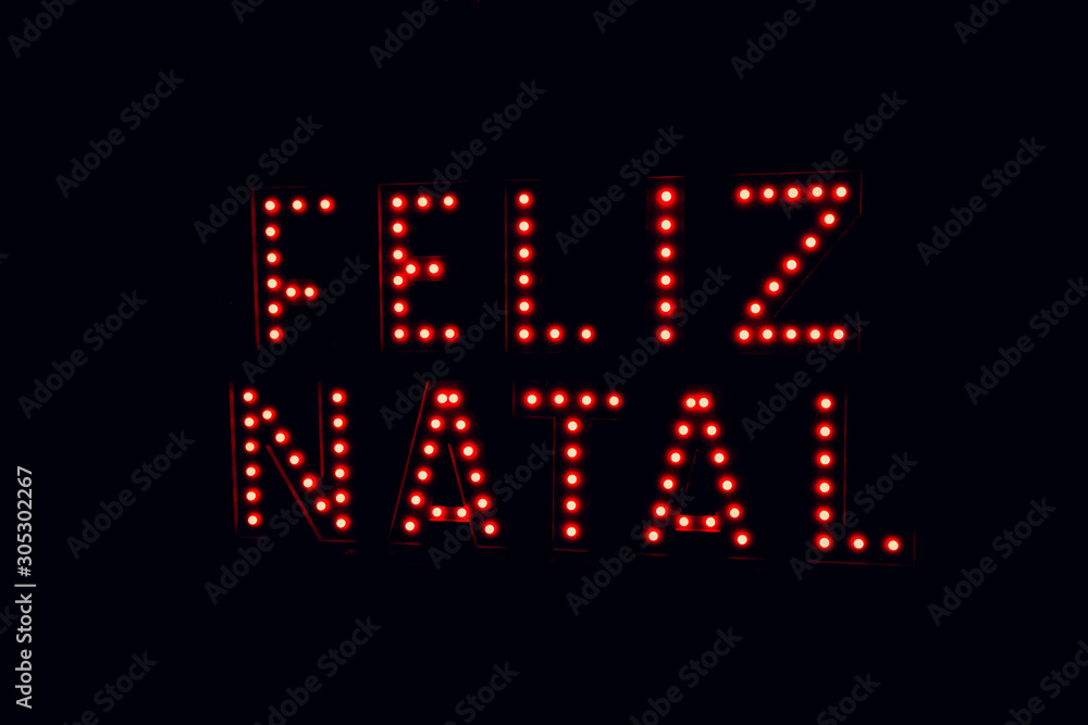 Merry christmas written in portuguese on neon red light black background Merry christmas written in portuguese on neon red light black background