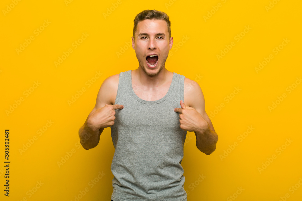 Young caucasian sport man surprised pointing with finger, smiling broadly. Young caucasian sport man surprised pointing with finger, smiling broadly.