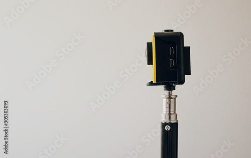 Small yellow camera on a tripod. The concept of recording movies on social media.
