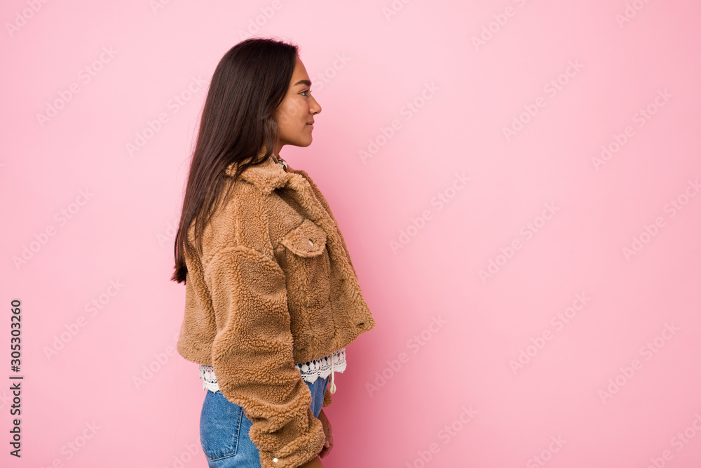 Young mixed race indian woman wearing a short sheepskin coatgazing left, sideways pose. Young mixed race indian woman wearing a short sheepskin coatgazing left, sideways pose.