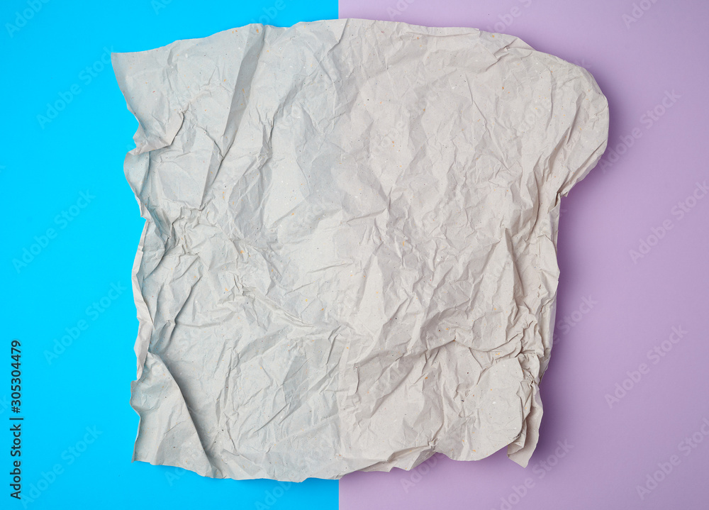 Obraz premium crumpled piece of gray paper on a colored background, top view