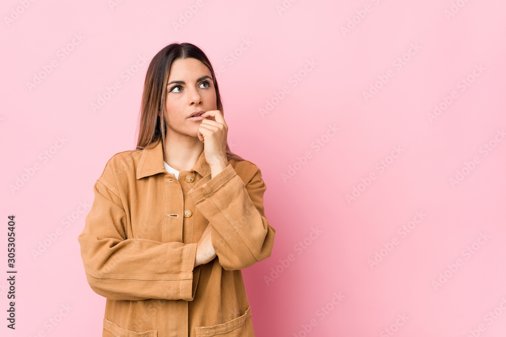 Young caucasian woman isolated relaxed thinking about something looking at a copy space. Young caucasian woman isolated relaxed thinking about something looking at a copy space.