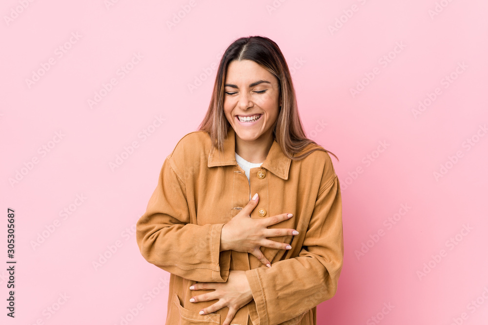 Young caucasian woman isolated laughs happily and has fun keeping hands on stomach. Young caucasian woman isolated laughs happily and has fun keeping hands on stomach.