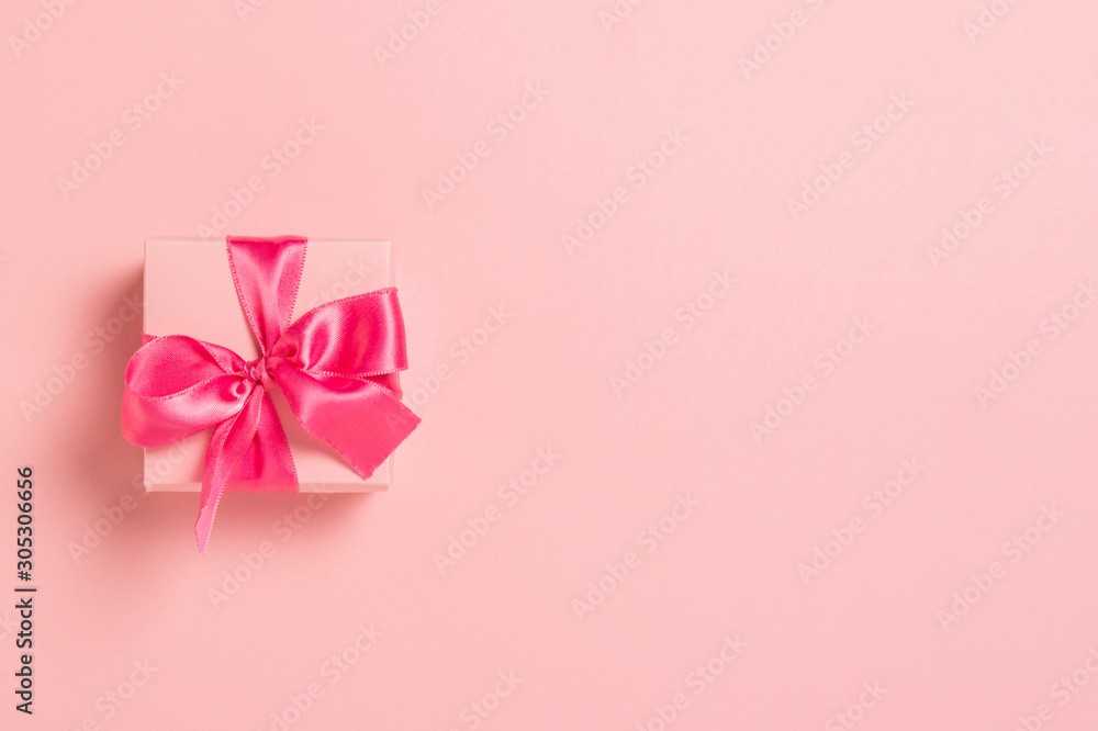 Pink gift box with pink ribbon on a pink background. Wedding concept, Valentine's Day, a gift for a loved one. Banner. Flat lay, top view Pink gift box with pink ribbon on a pink background. Wedding concept, Valentine's Day, a gift for a loved one. Banner. Flat lay, top view