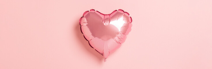 Pink air balloon heart shape on a pink background. Wedding concept, Valentine's Day, a gift for a loved one. Banner. Flat lay, top view