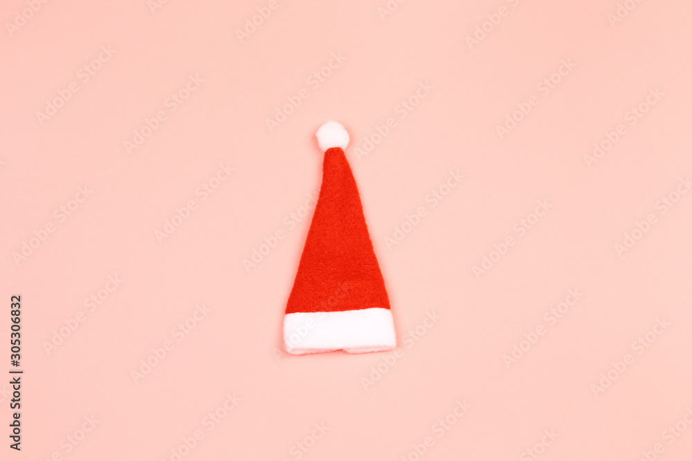 Santa Claus hat on a pink background. minimalistic christmas scandy background with empty place for text Santa Claus hat on a pink background. minimalistic christmas scandy background with empty place for text