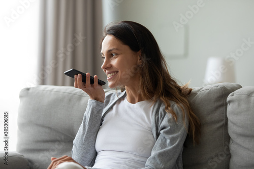 Woman spent time at home holding smartphone using voice messaging