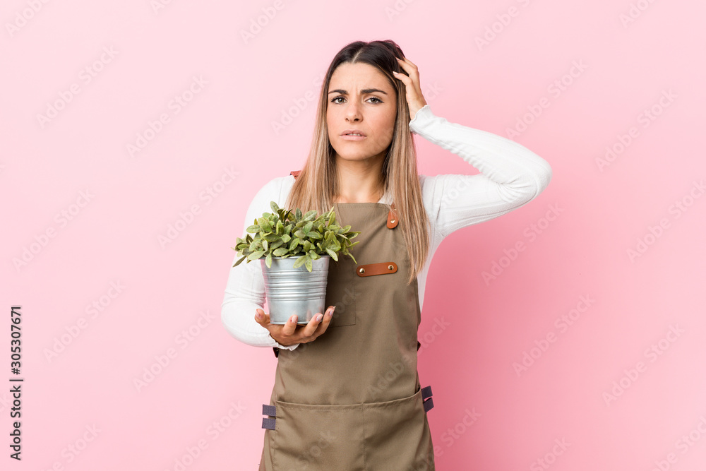 Young gardener woman holding a plant being shocked, she has remembered important meeting. Young gardener woman holding a plant being shocked, she has remembered important meeting.