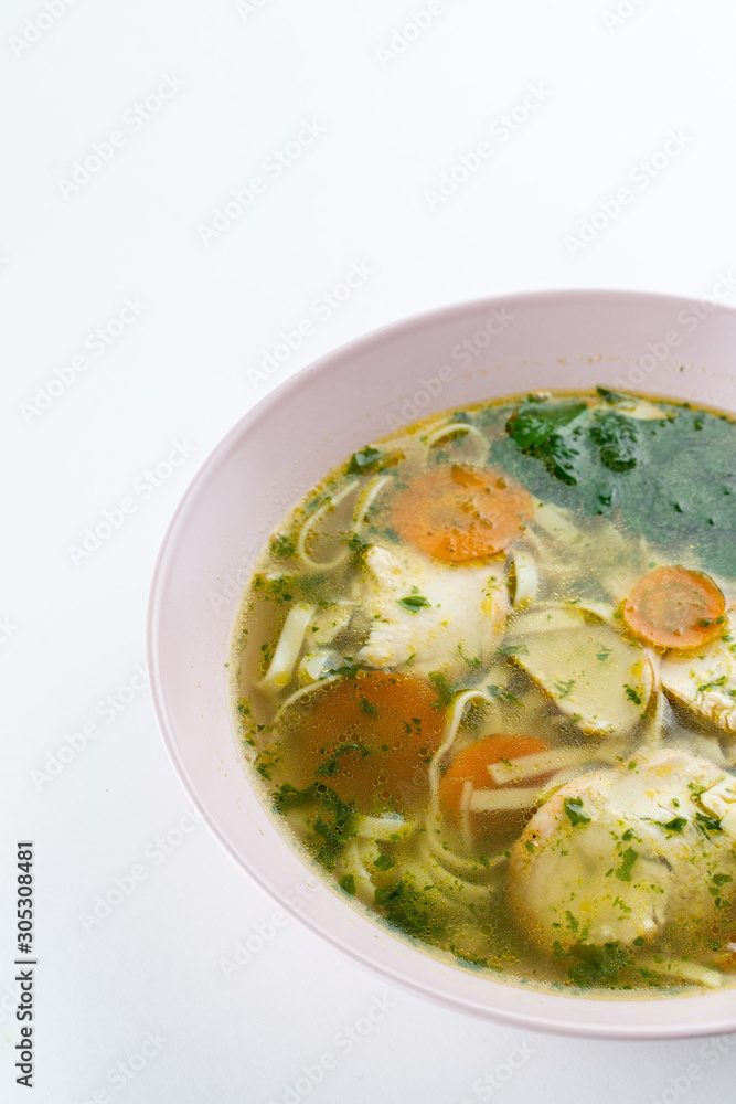Classic chicken noodle soup with carrot and parsley isolated on white Classic chicken noodle soup with carrot and parsley isolated on white