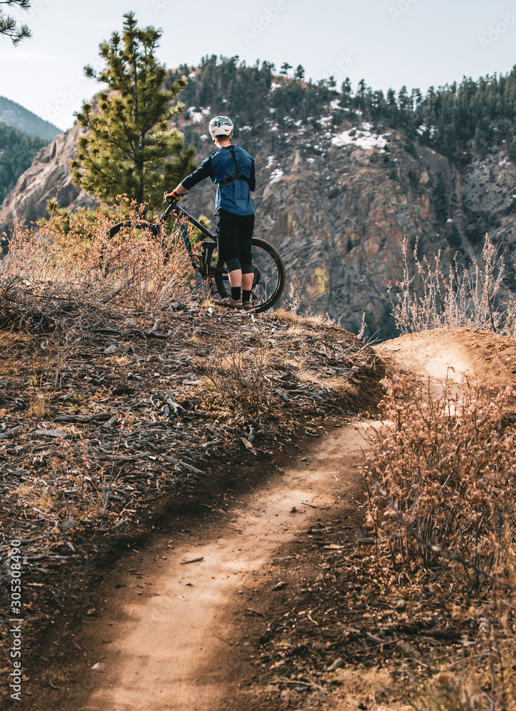 Naklejka premium man on mountain biking trail 