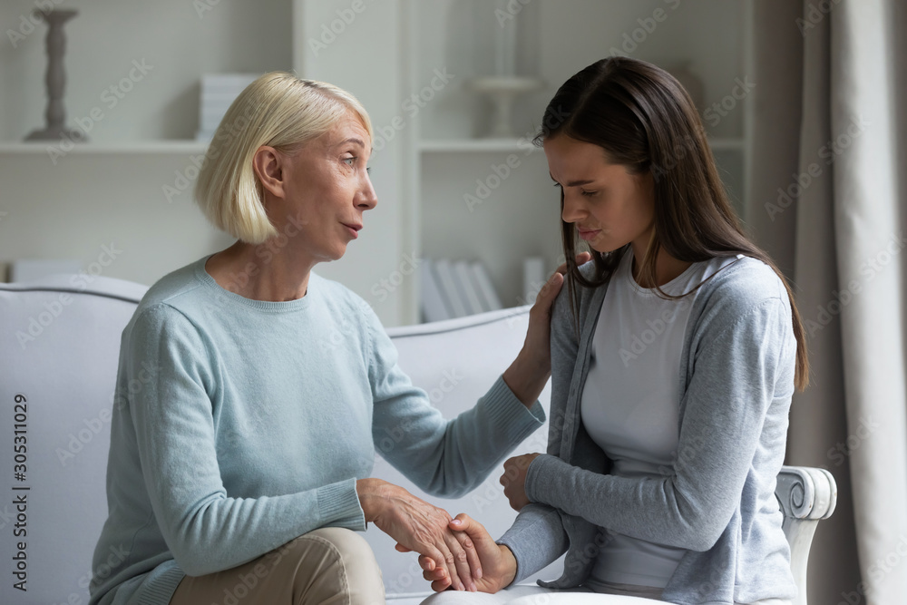 60s mom calming grownup daughter giving support showing care 60s mom calming grownup daughter giving support showing care