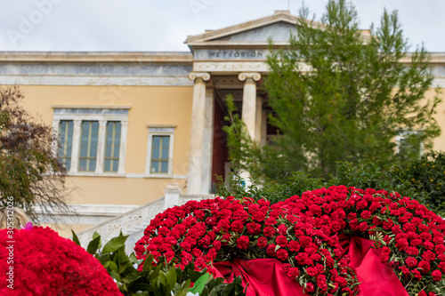 Athens, Greece - November 17th, 2019: Red flowers next the Polytechnio University to conmemorate the 46th aniversary of the uprising students against the Greek junta in 1973. photo