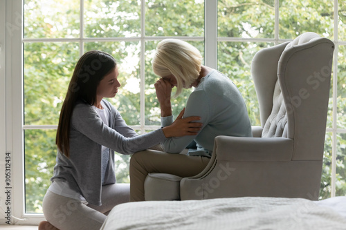 Daughter comforting elderly mother sharing difficult life period giving support photo