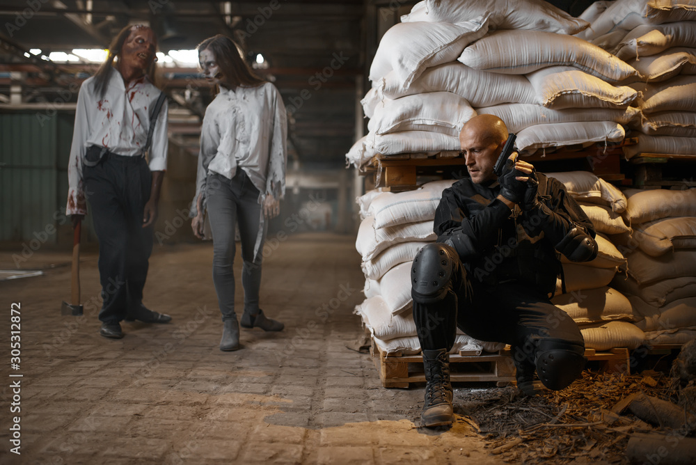 Military man hides from zombies, abandoned factory Military man hides from zombies, abandoned factory