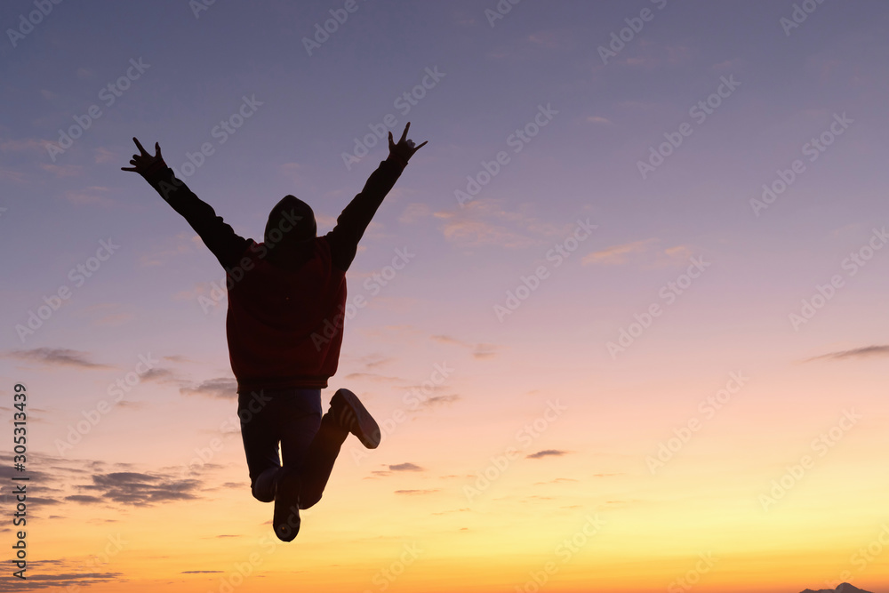 Silhouette of happy people jumping playing on mountain at sunset or sunrise Silhouette of happy people jumping playing on mountain at sunset or sunrise