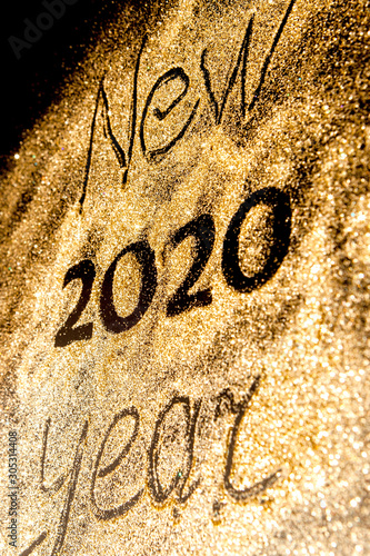 Happy New Year 2020. Beautiful sparkling Golden number 2020 on black background for design With Copy Space For Text. Beautiful Glowing overlay template for holiday greeting card