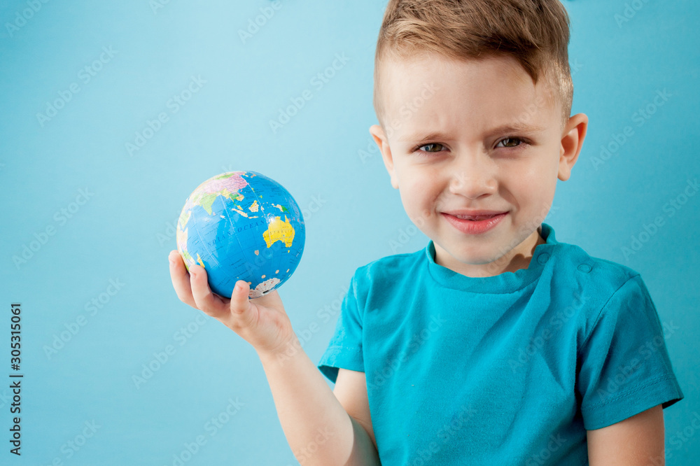 Little boy holding a globe on blue background Little boy holding a globe on blue background