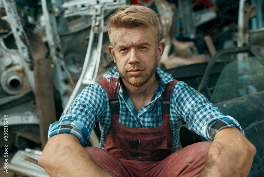 Dirty male repairman with wrench on car junkyard Dirty male repairman with wrench on car junkyard