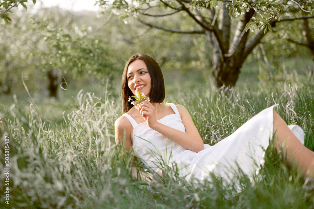 Cheerful woman with flowers resting in garden Cheerful woman with flowers resting in garden