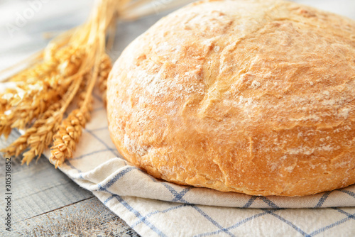 Fresh bread with spikelets on table
