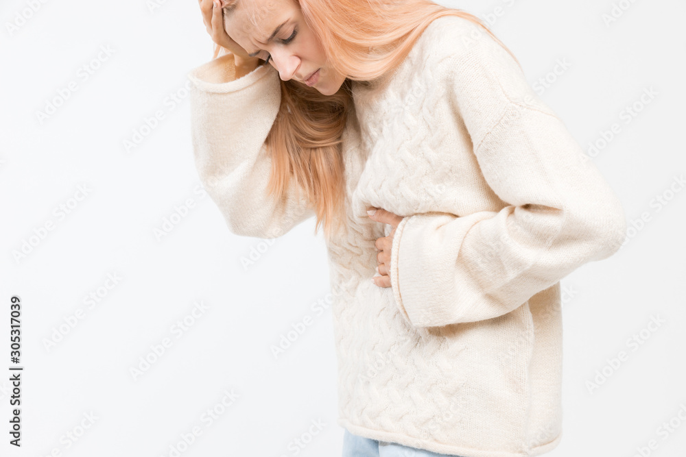 Cropped studio portrait of woman in white sweater suffering from abdominal pain, having menstruation pain, stomach ache. Girl feels bad. Menstrual period, gynecology, gastritis. Healthcare concept. Cropped studio portrait of woman in white sweater suffering from abdominal pain, having menstruation pain, stomach ache. Girl feels bad. Menstrual period, gynecology, gastritis. Healthcare concept.