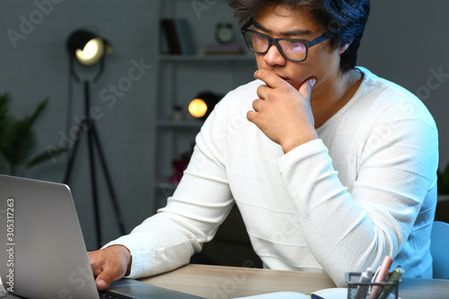 Asian programmer working la...