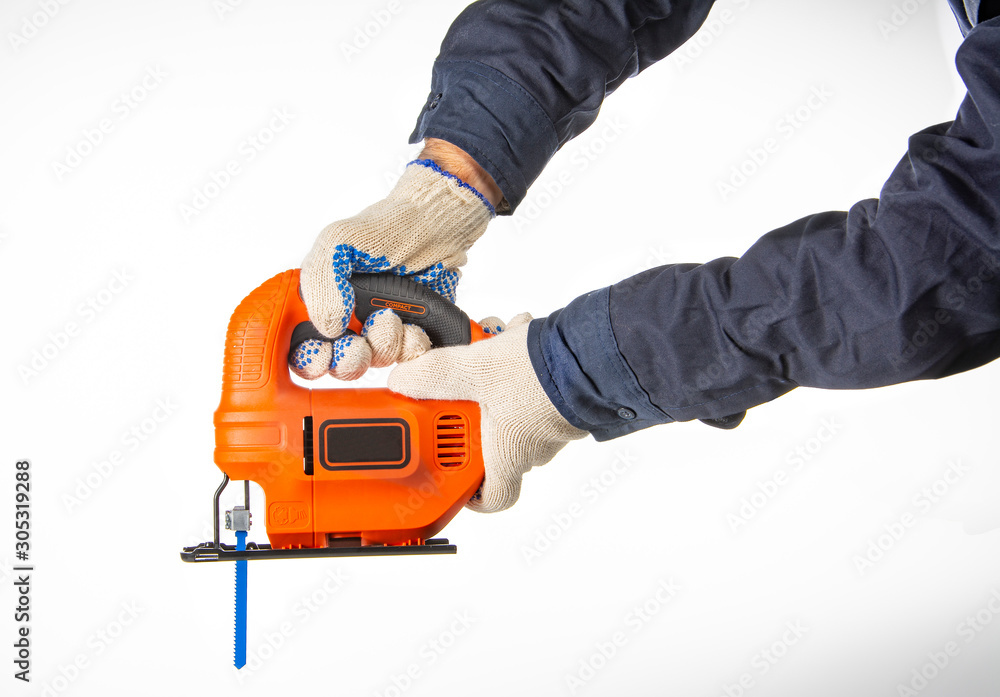 Fototapeta premium brazos de hombre con buzo azul y guantes agarrando una herramienta 