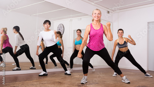 Cheerful different ages women learning swing steps at dance class