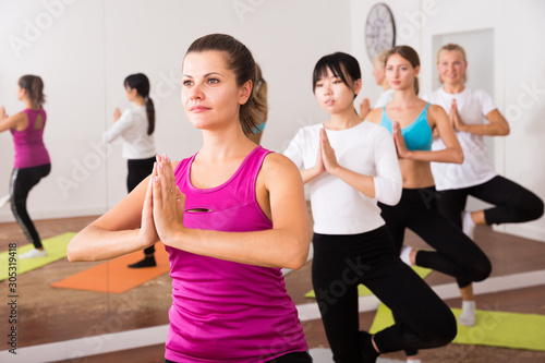 Fototapeta Naklejka Na Ścianę i Meble -  Women exercising yoga poses in fitness center