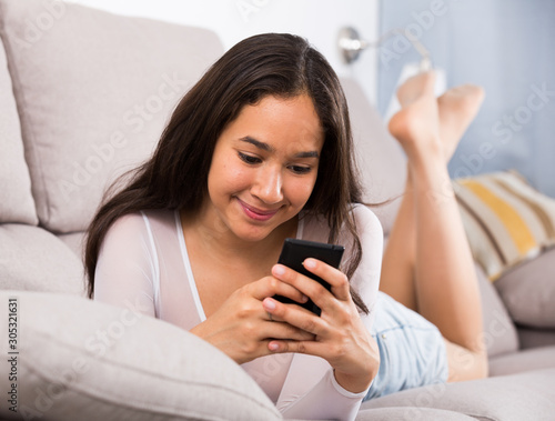 Cheerful teenager girl relaxation with phone photo