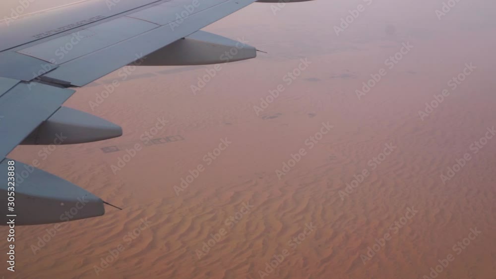 Aerial view out of an Etihad Airways Airbus A320-200s right window on final approach on Abu Dhabi international airport with the red sand dunes in the background while sunset. Aerial view out of an Etihad Airways Airbus A320-200s right window on final approach on Abu Dhabi international airport with the red sand dunes in the background while sunset.