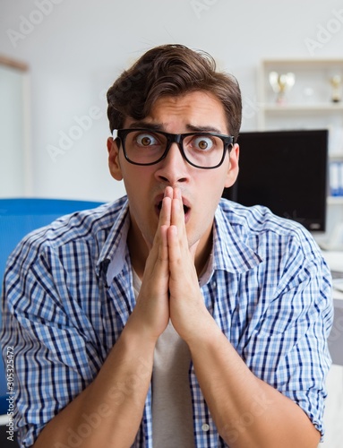 Businessman sitting in front of many screens