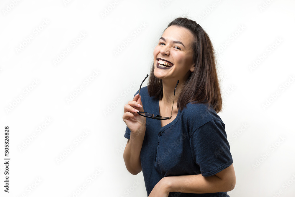 Romantic girl in trendy glasses posing with shy smile. Studio close-up portrait on a white background. Romantic girl in trendy glasses posing with shy smile. Studio close-up portrait on a white background.