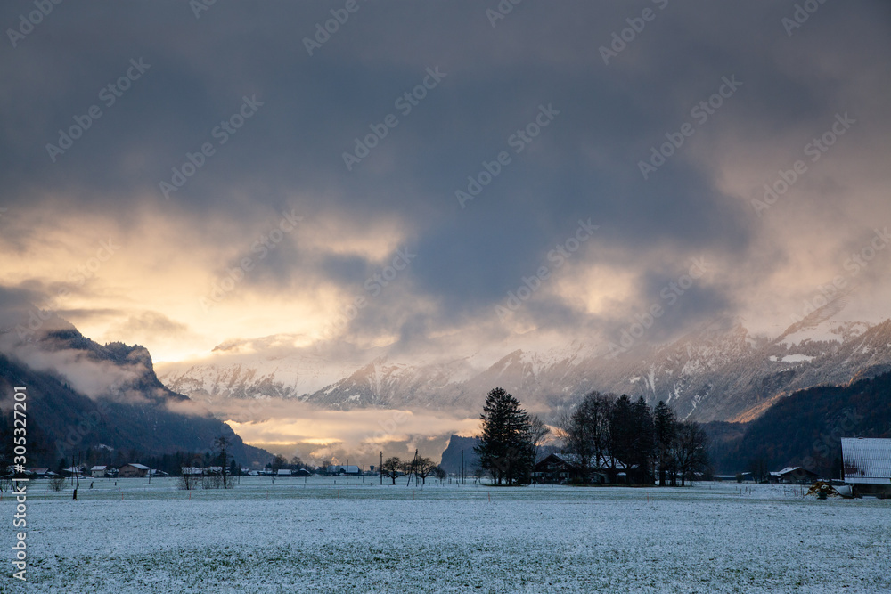 sunset and snow covered peaks in the background  Switzerland