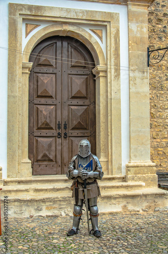Obidos/Portugal - medieval knight stands at the entrance to the castle. © Liudmila